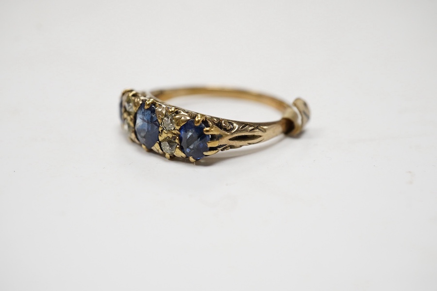 A yellow metal and three stone sapphire and four stone diamond set half hoop ring, size P/Q, gross weight 3.3 grams. Condition - poor to fair